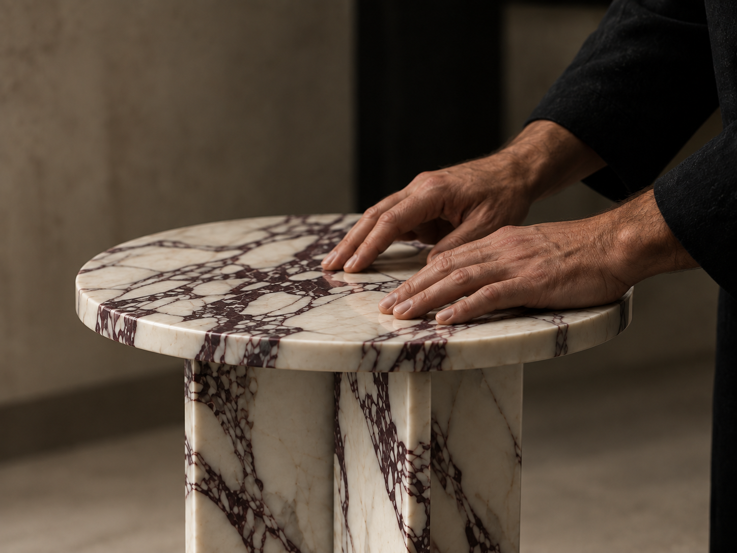 Hands on a veined Calacatta Viola marble table by OROS
